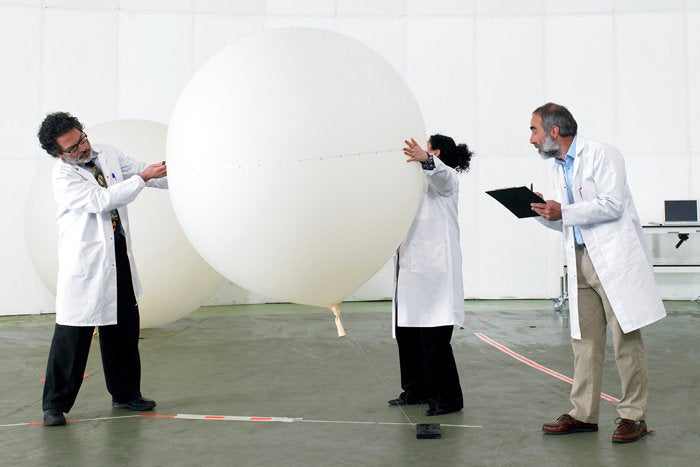 3 people in lab coats testing balloon QA