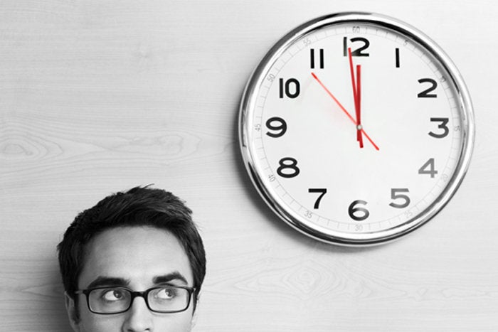 Man looking up at clock on wall deadline
