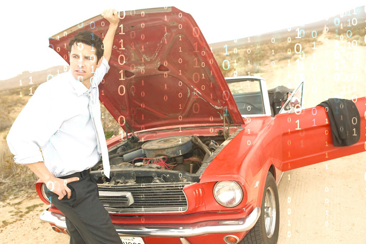 Broken down red mustang with man holding up car hood