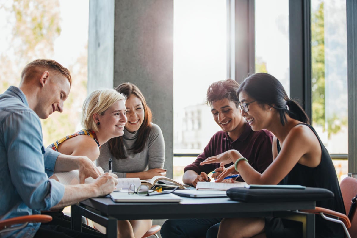 Group of workers collaborating at table with mobile devices