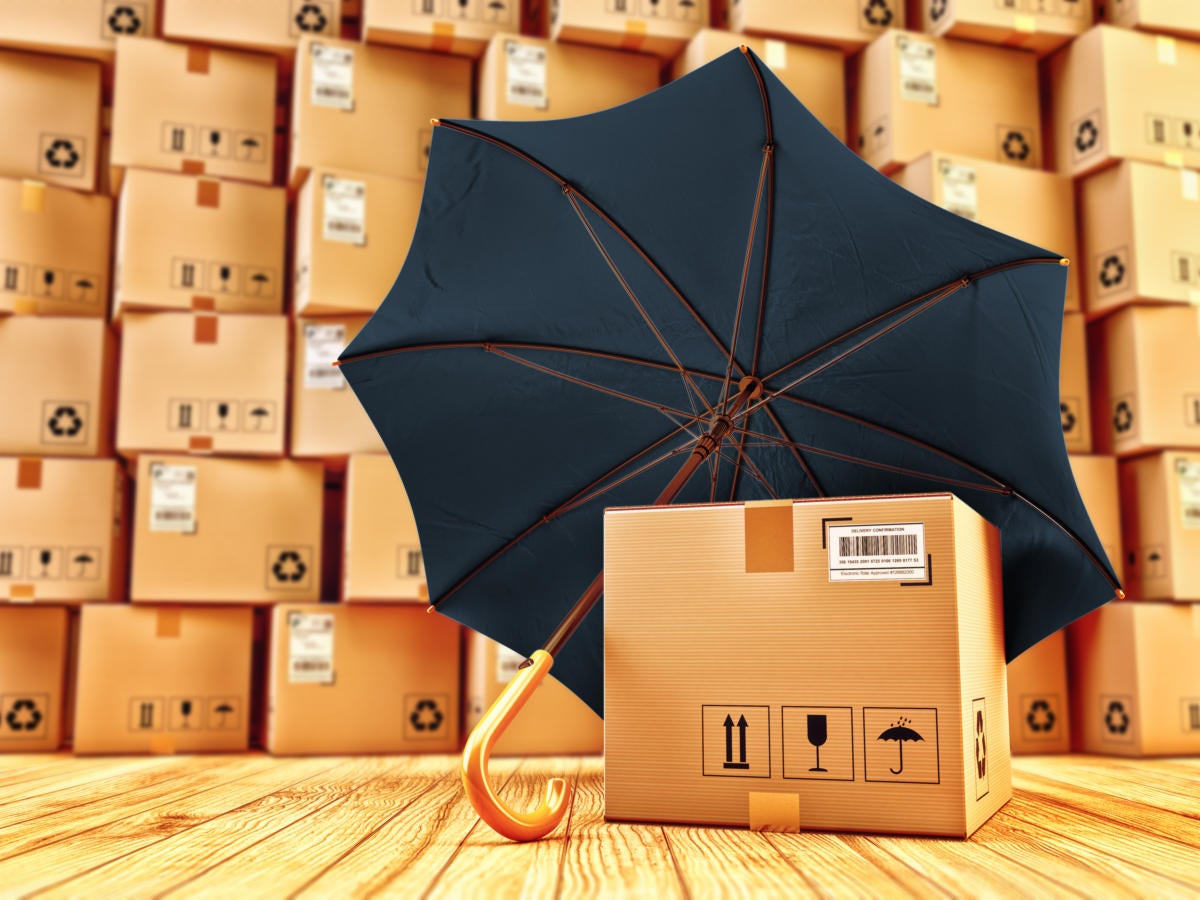 Parcels and stacked packages being protected by black umbrella