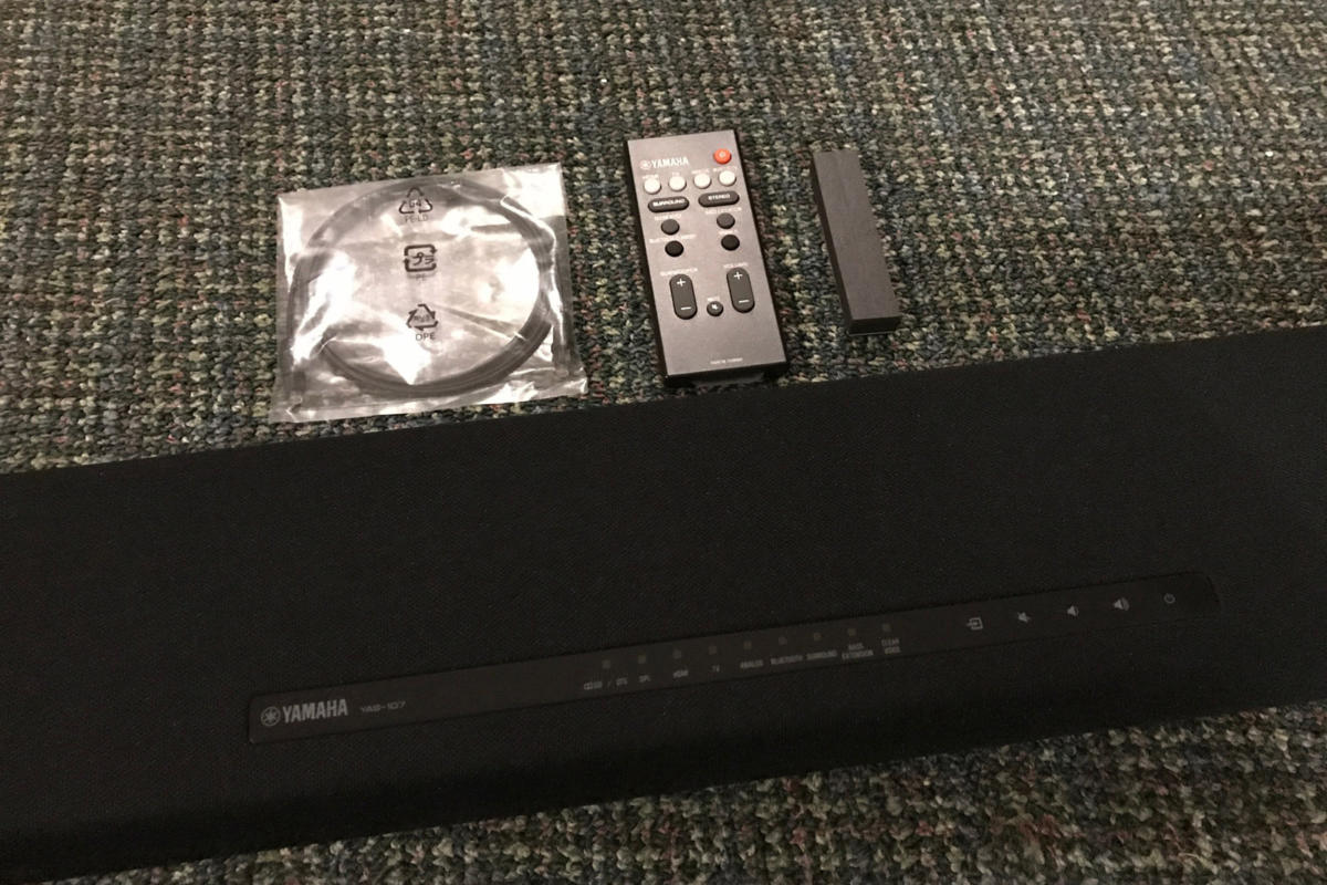 The Yamaha YAS-107 includes a basic remote, Toslink digital audio cable, and rubber pads.