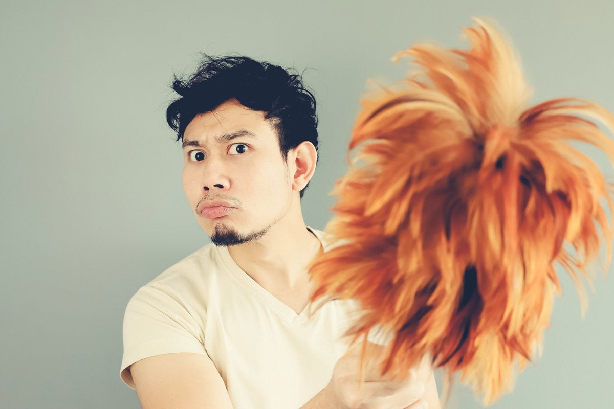 man with feather duster makeover clean dust
