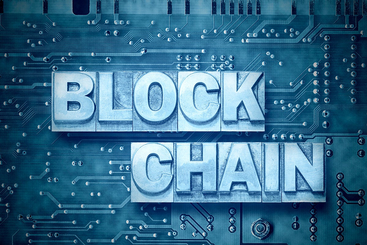 'blockchain' set in metal type against a circuit board