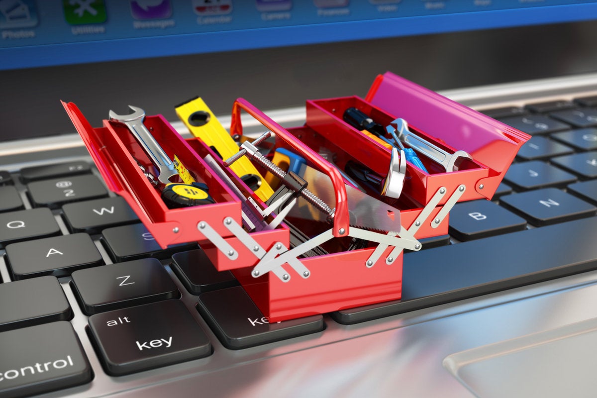 a miniature toolbox or toolkit on a laptop keyboard to build, develop or repair