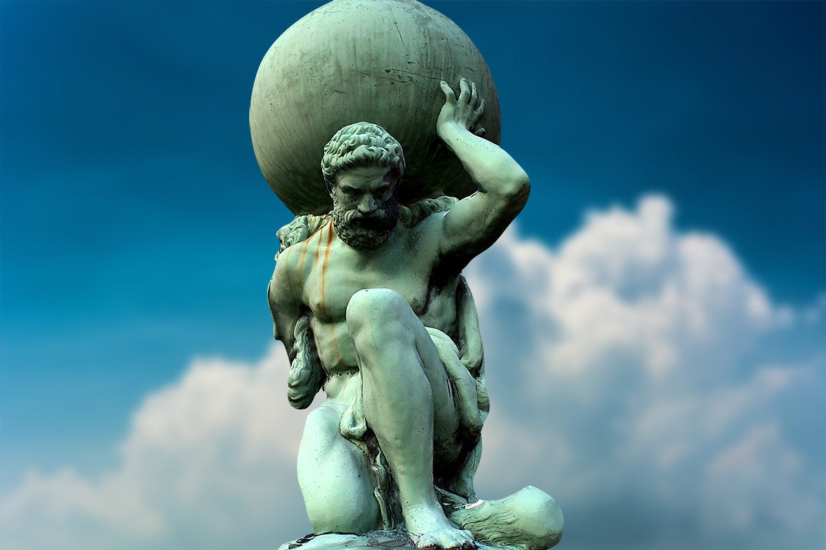 Statue of Atlas against a blue sky and large white clouds.