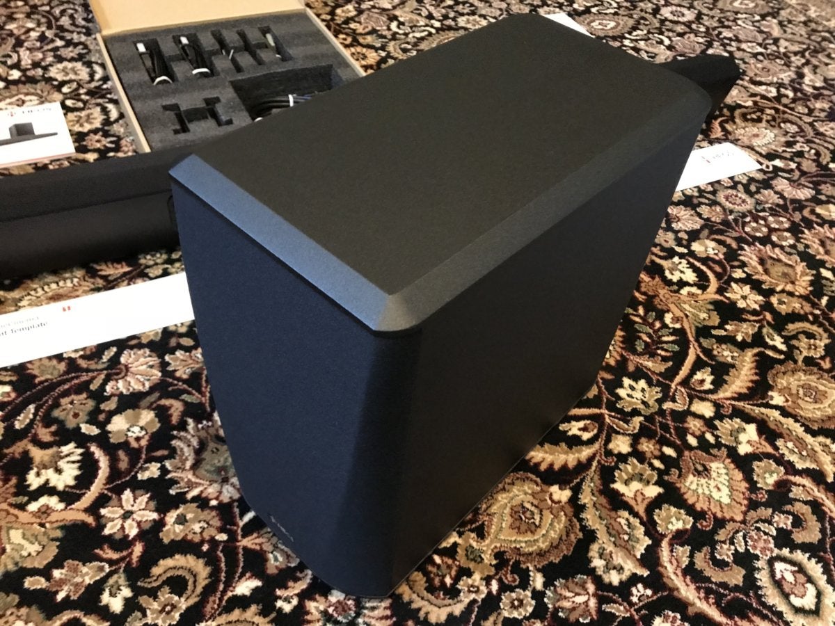 The included wireless subwoofer has a tall, slim profile.