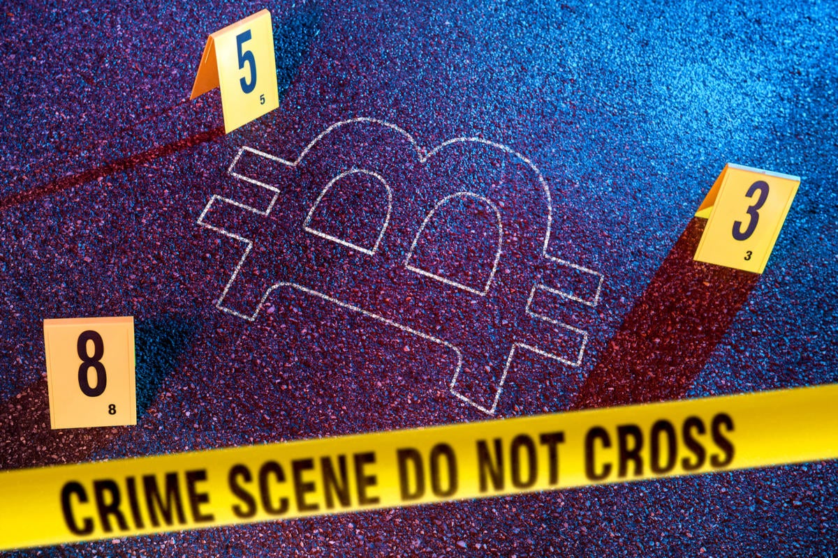 Bitcoin symbol on the ground surrounded by crime scene tape and forensic evidence markers.