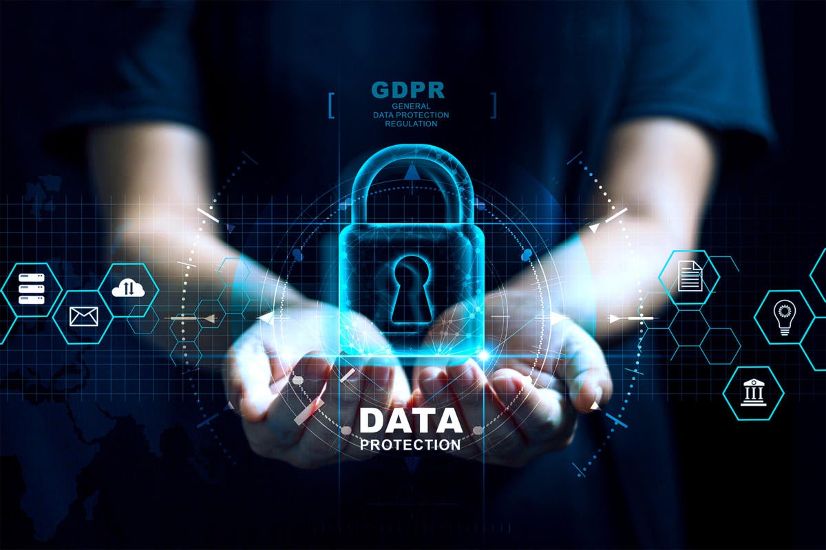  A person in dark clothing is holding a glowing blue padlock with the text 'Data Protection' in front of their chest with other glowing blue icons around them including a cloud icon with the text 'GDPR' and a globe icon.