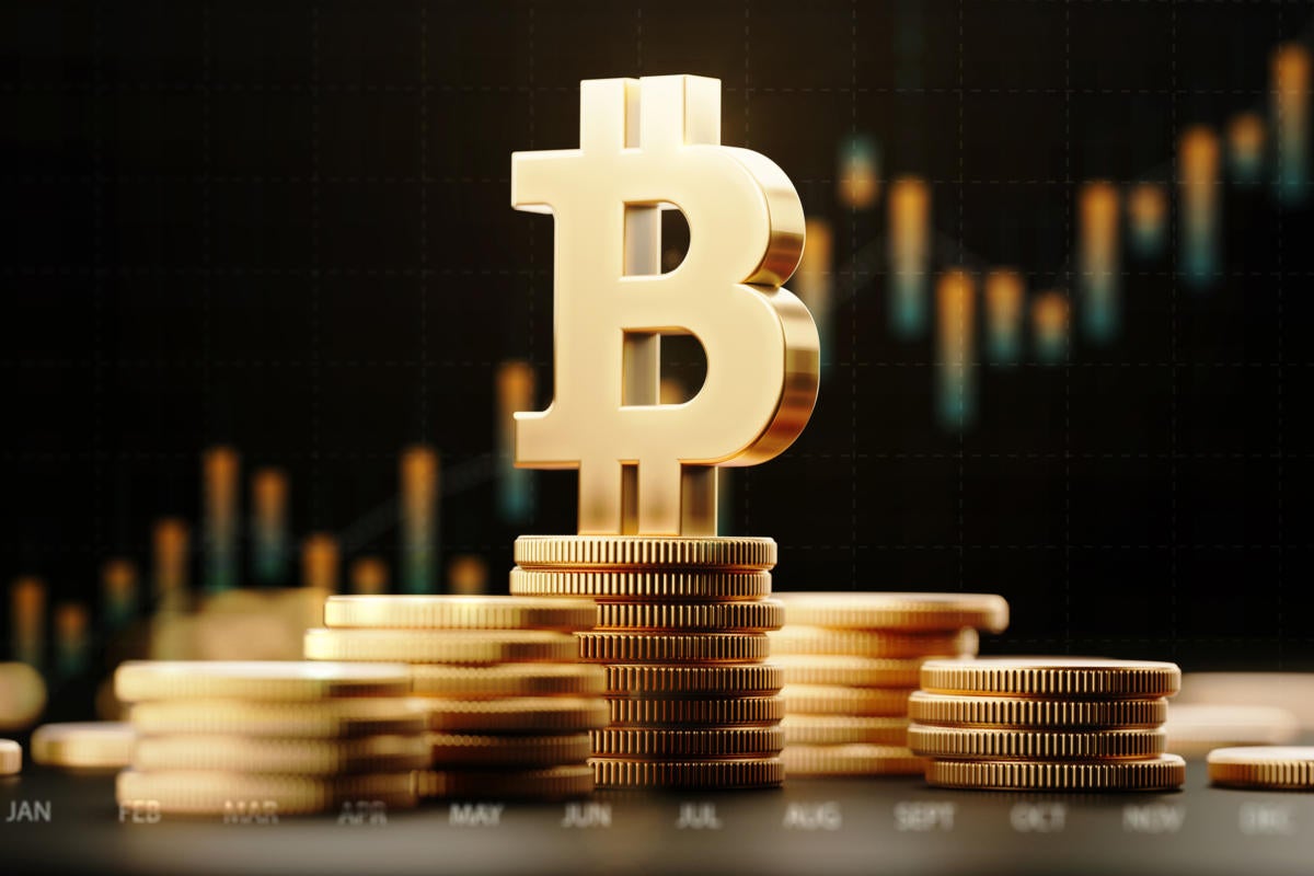 Bitcoin symbol atop stacked bitcoins with abstract financial chart data