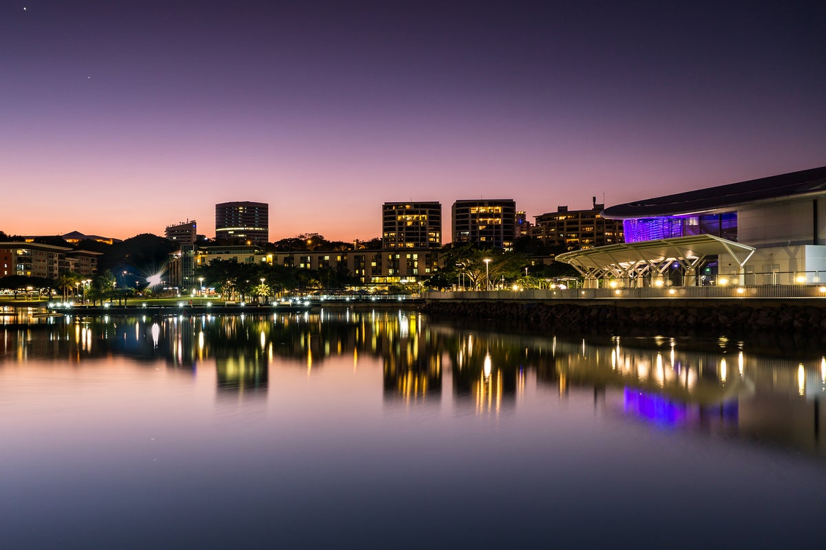 The Darwin waterfront in NT at dusk [Sky is purple, water reflects the buildings]