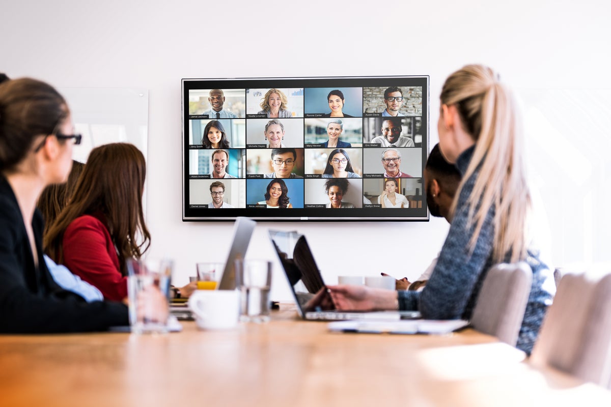 Zoom video conferencing  >  People in a conference room are connected with remote participants.
