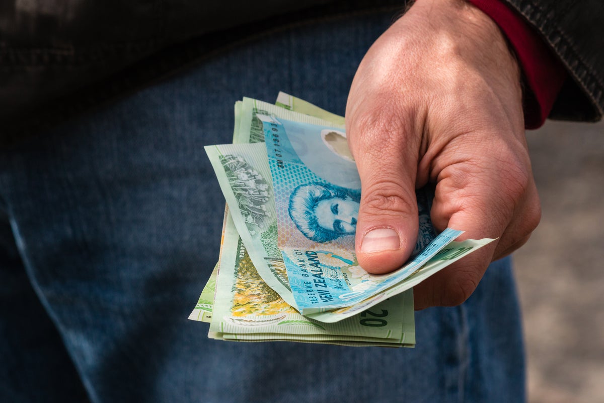 new zealand money 100 currency man holding money by patrikstredrak getty images
