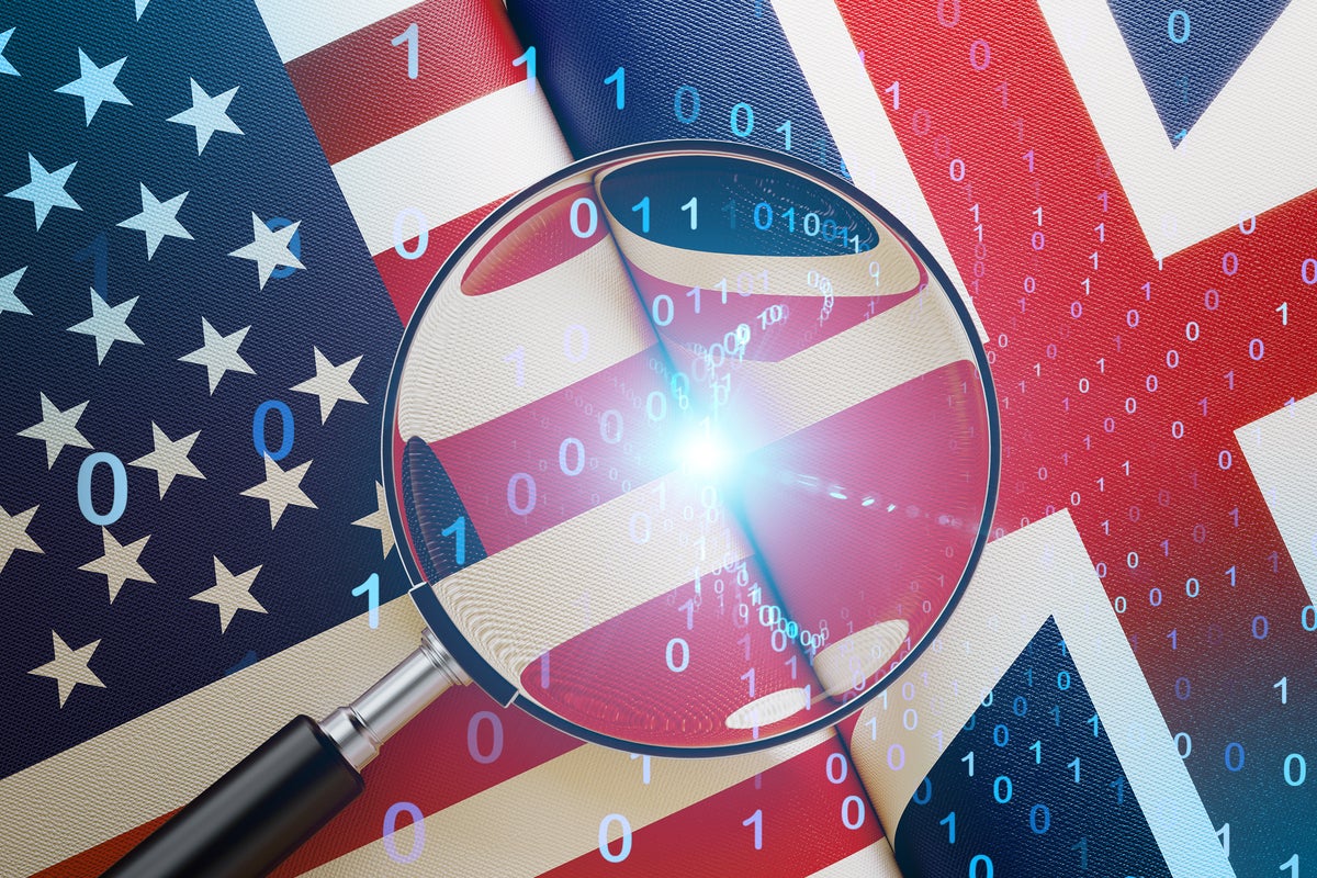 United States-United Kingdom flags with binary data flow under a magnifying lens.
