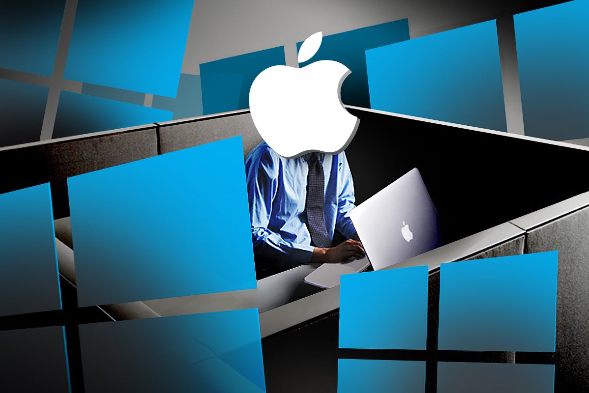A businessman with Apple-logo head uses a MacBook laptop, surrounded by Microsoft Windows logos.
