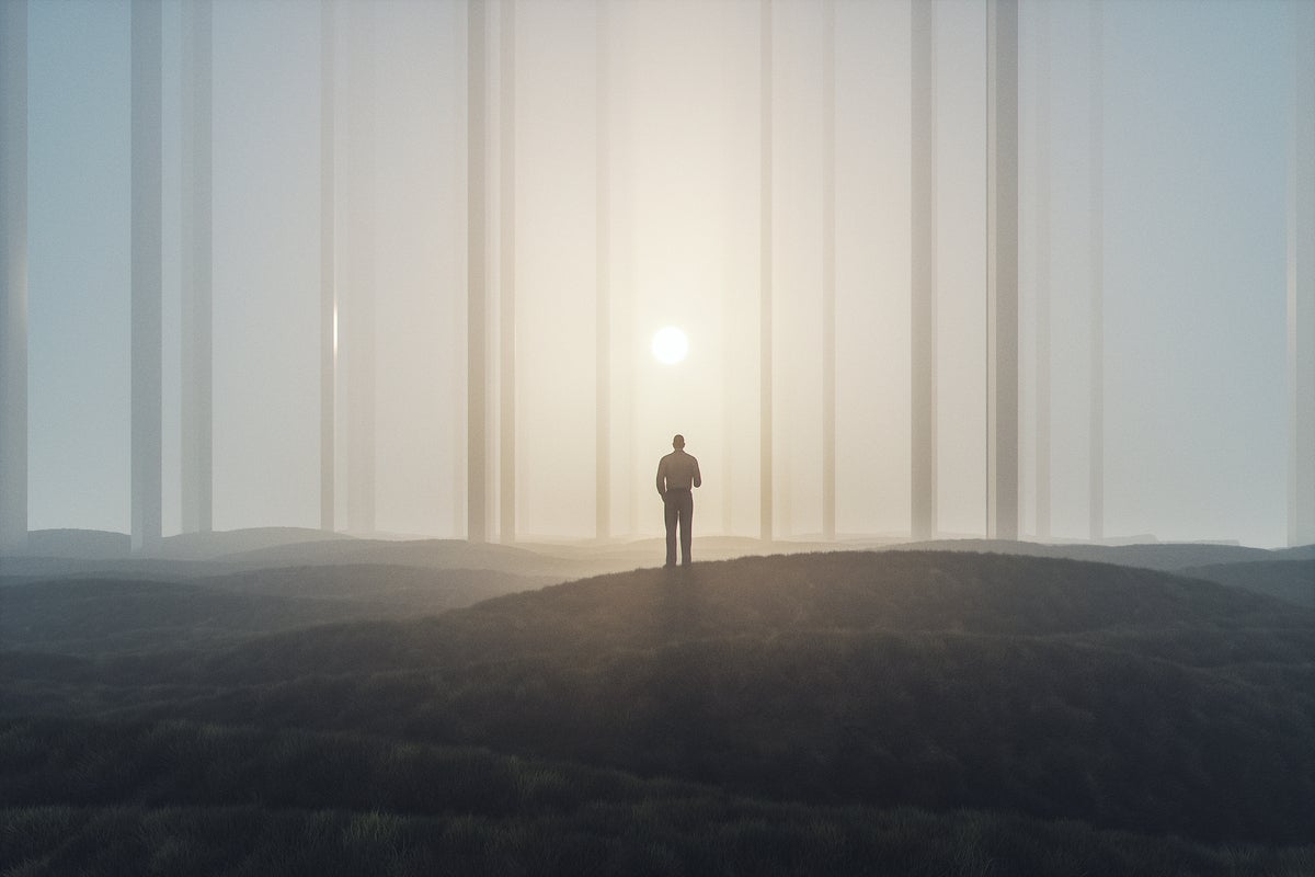 Sun shines through the trees beyond a silhouette, alone in forest.