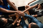 Hands are stacked together in unity and trust. [colleagues / teamwork / collaboration]