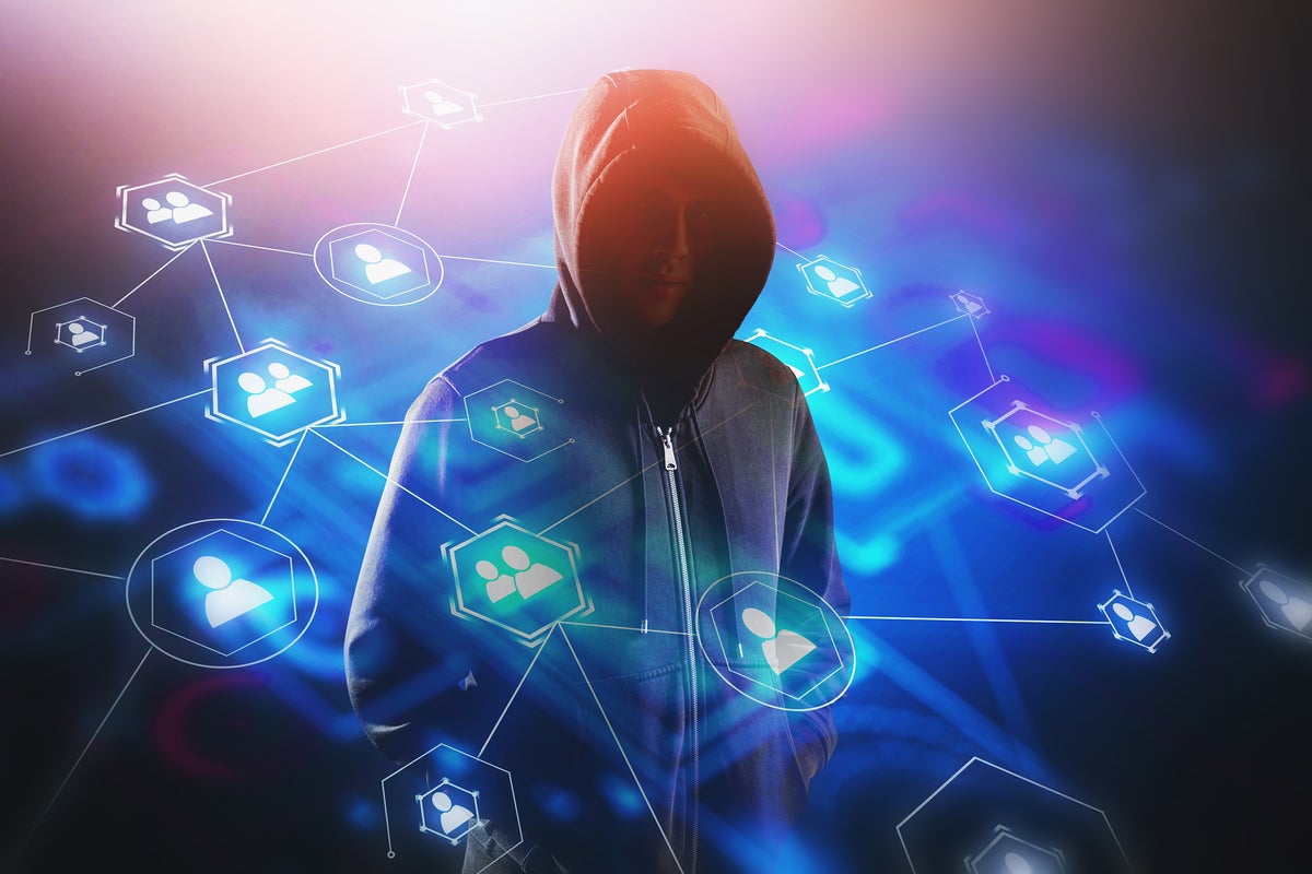 An anonymous hooded figure is surrounded by an abstract network of avatars.