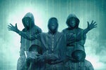 A group of anonymous hooded figures exist amid raining streams of binary code. [security threats]