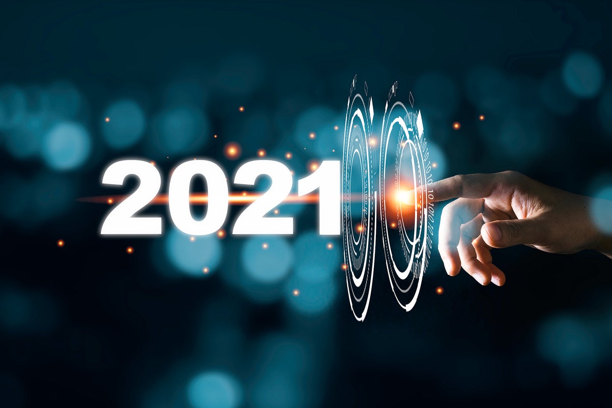 A hand touches a virtual interface rippling forward into 2021.