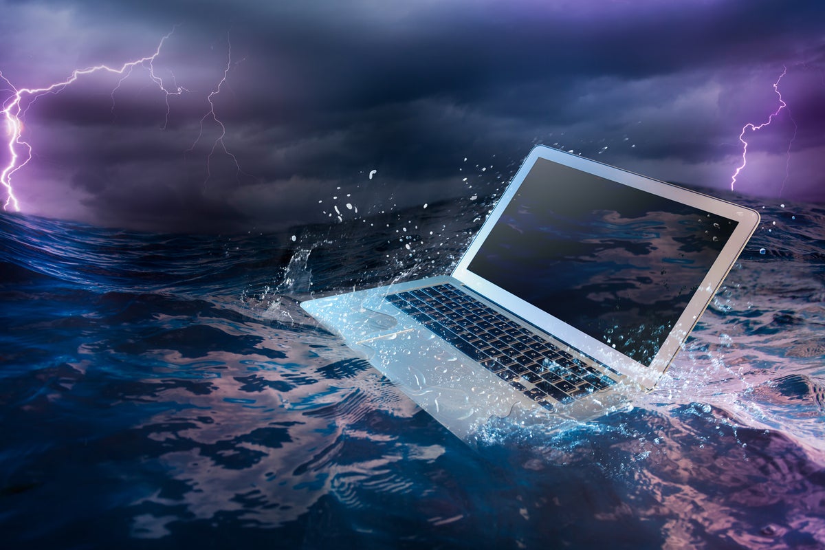 A laptop sits on the surface of a stormy sea. [disaster recovery / crisis management]