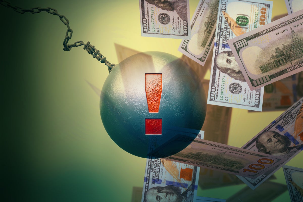 A recking ball with exclamation point smashes into U.S. hundred-dollar bills.