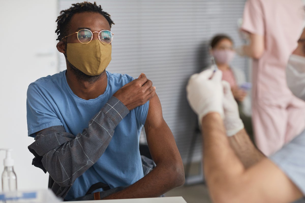 COVID-19 vaccine is administered to masked patients at a vaccination center.