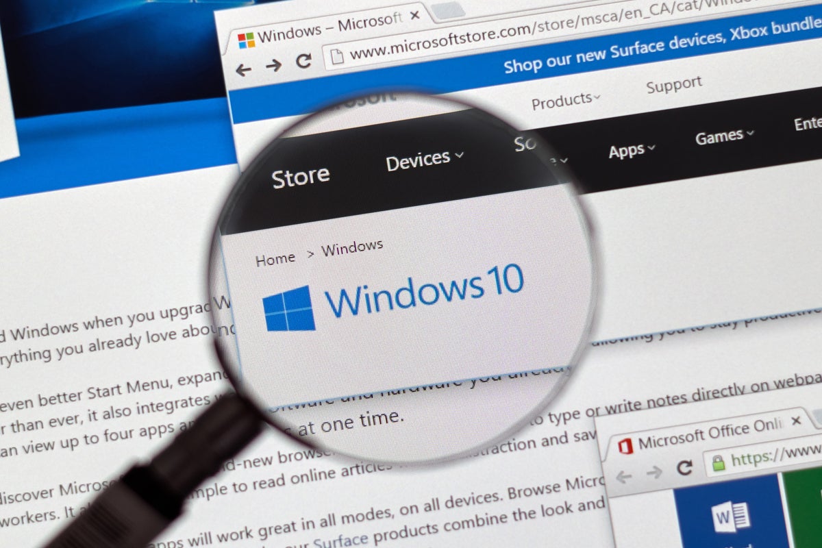 A magnifying lens hovers over the Windows 10 logo.