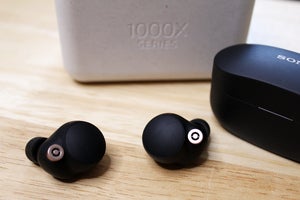 Sony WF-1000XM4 earbuds with packaging and case nearby