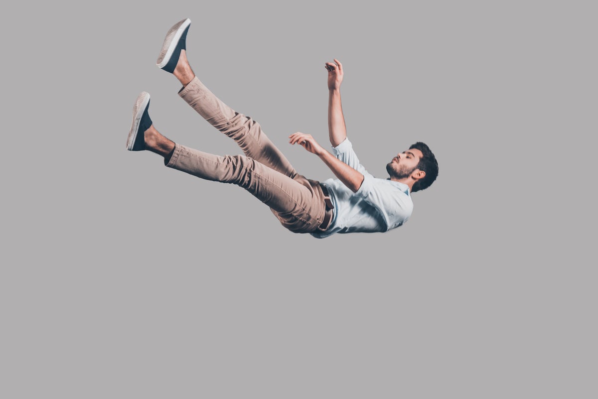 man falling against gray background