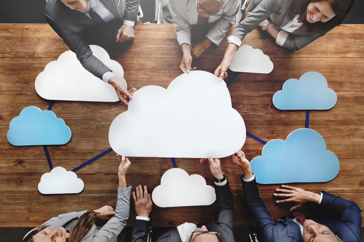 Business people joining together to touch cloud cut-out