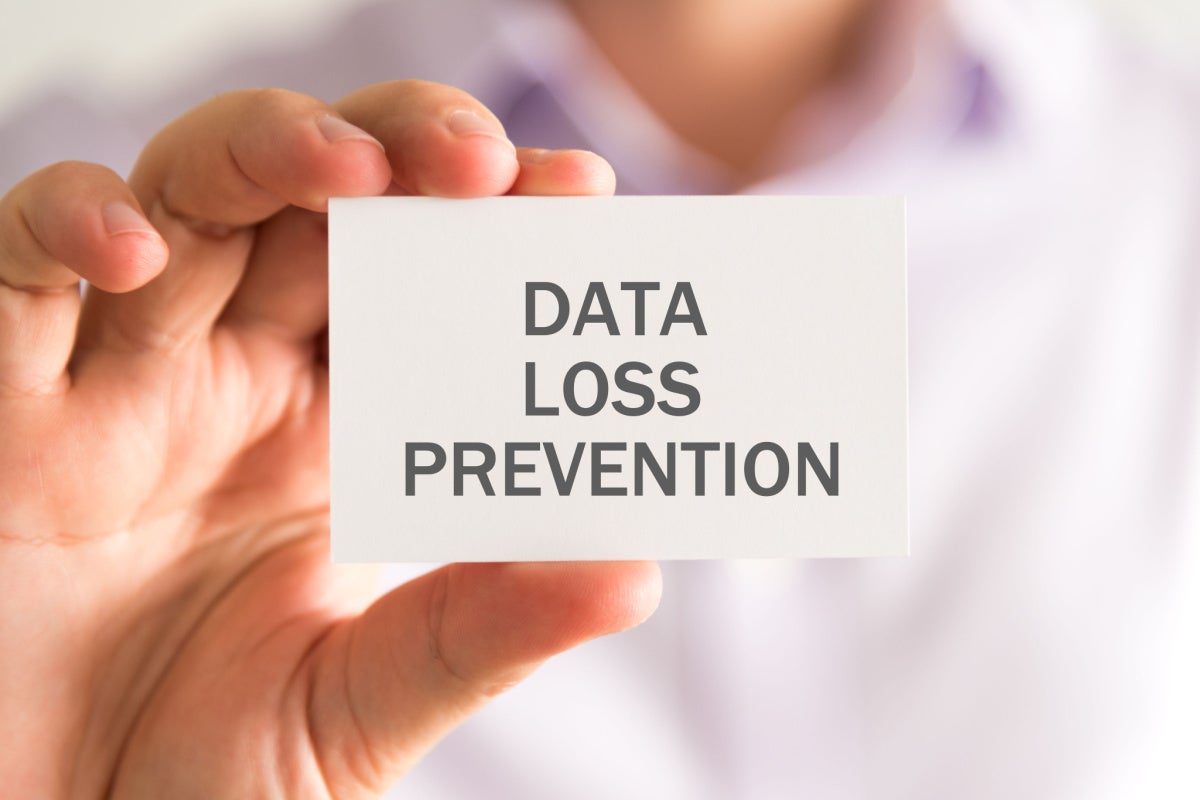 Closeup on businessman holding a card with DLP Data Loss Prevention message