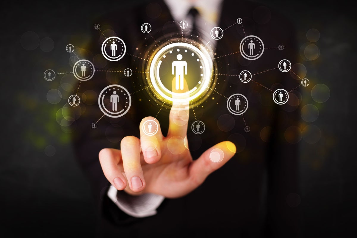 Business man touching a button with a person icon and it connects to several other buttons