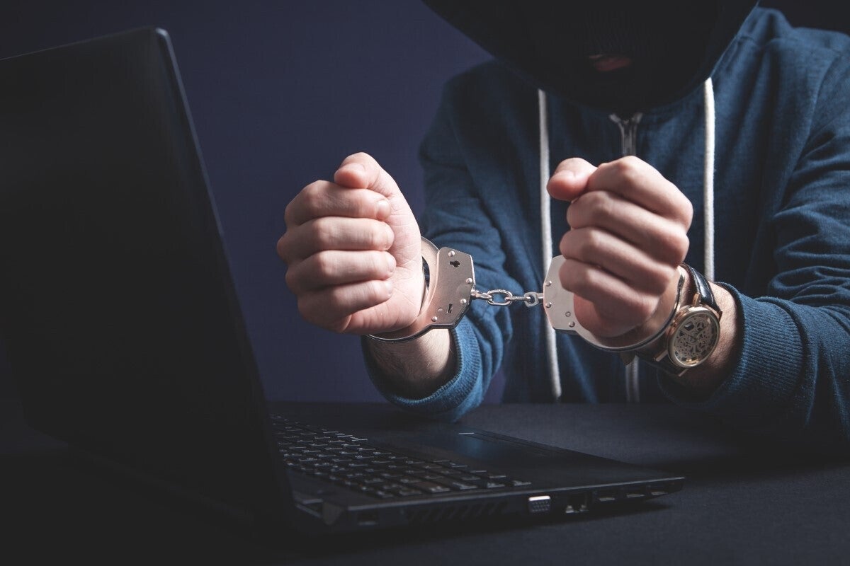 hacker handcuffs laptop cybercrime cyber crime arrested