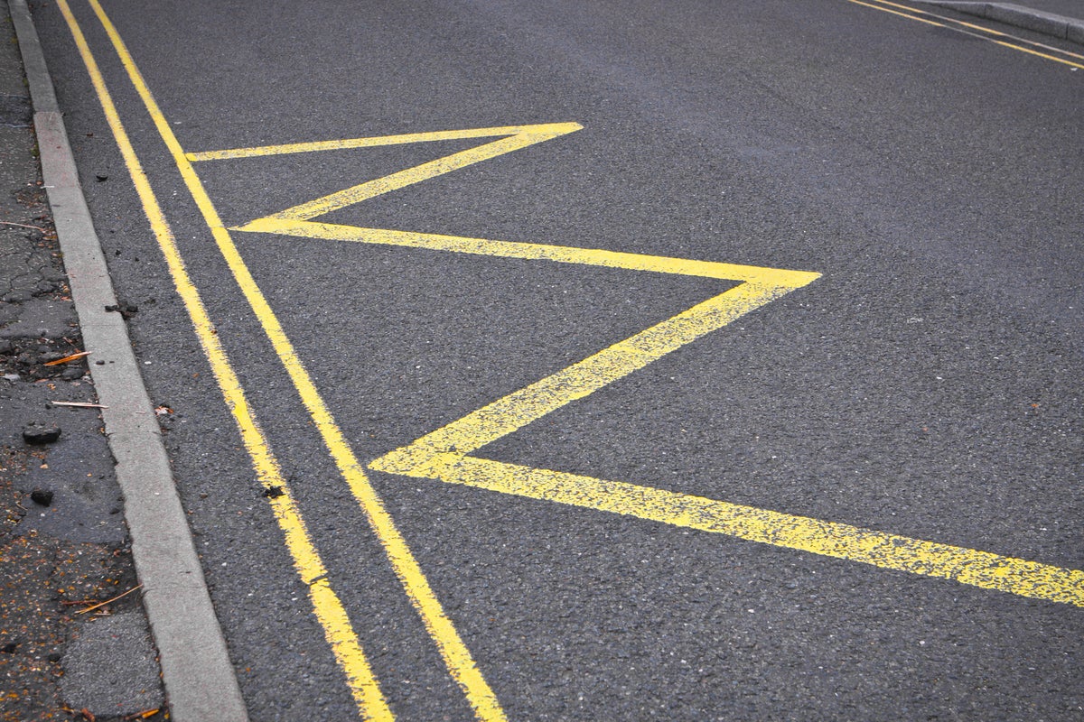 Zig zag road sign. Yellow lines on asphalt.