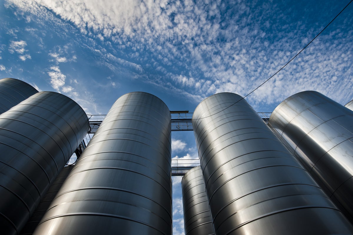 shutterstock 289153913 upward view of silver silos against a blue sky with clouds