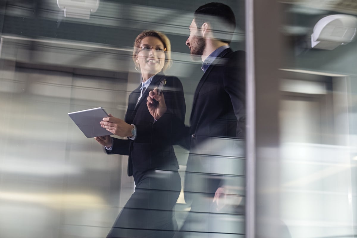 Two Business coworkers walking along elevated walkway