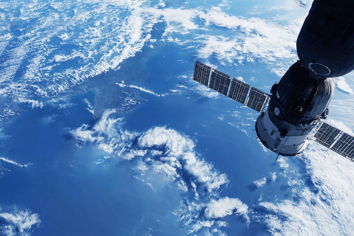 shutterstock 2291065933 space satellite in orbit above the Earth white clouds and blue sea below