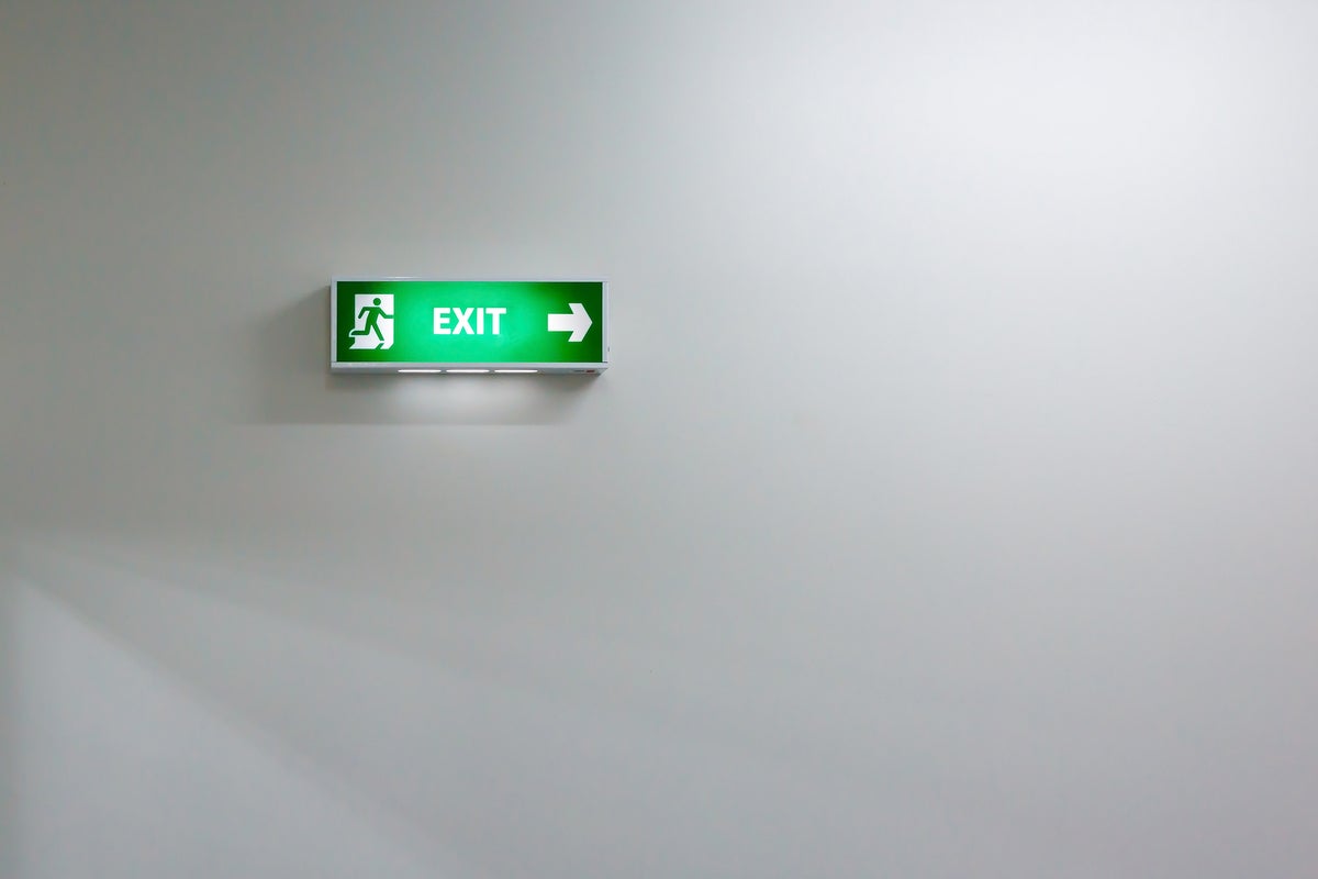 shutterstock 234875881 green fire exit sign against an indistinct soft white background