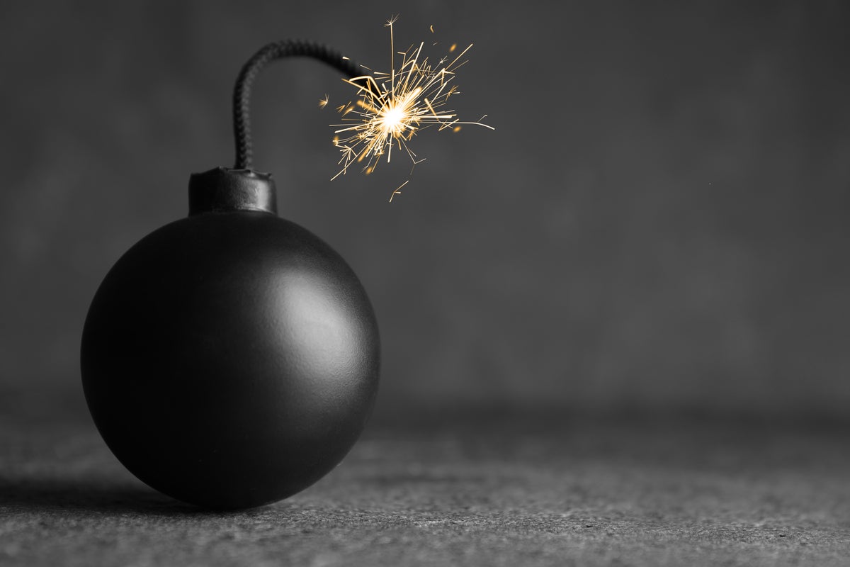 shutterstock 1951501180 old fashioned bomb with lit fuse against gray background
