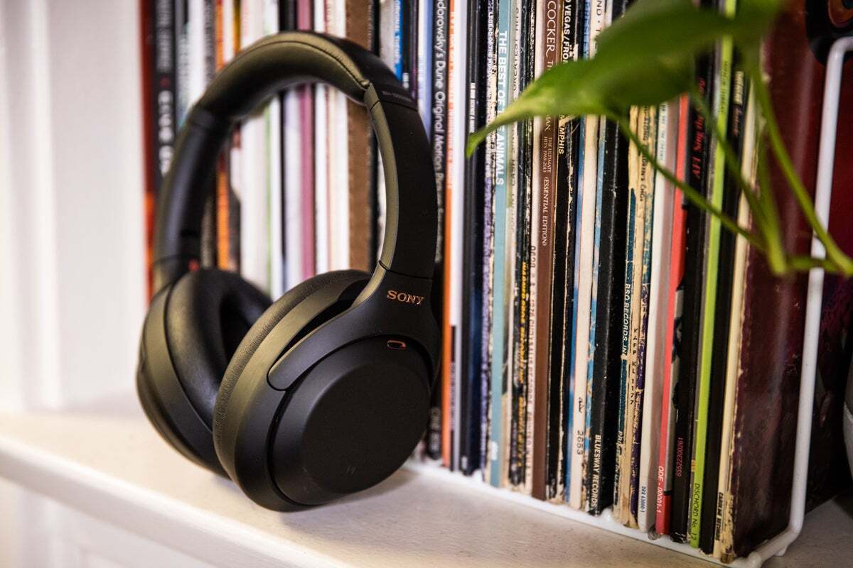 a pair of sony over-the-ear headphones leaning against a rack of LP album covers