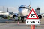 Airplane at the airport with a coronavirus sign in the foreground [Covid-19, travel, planes]