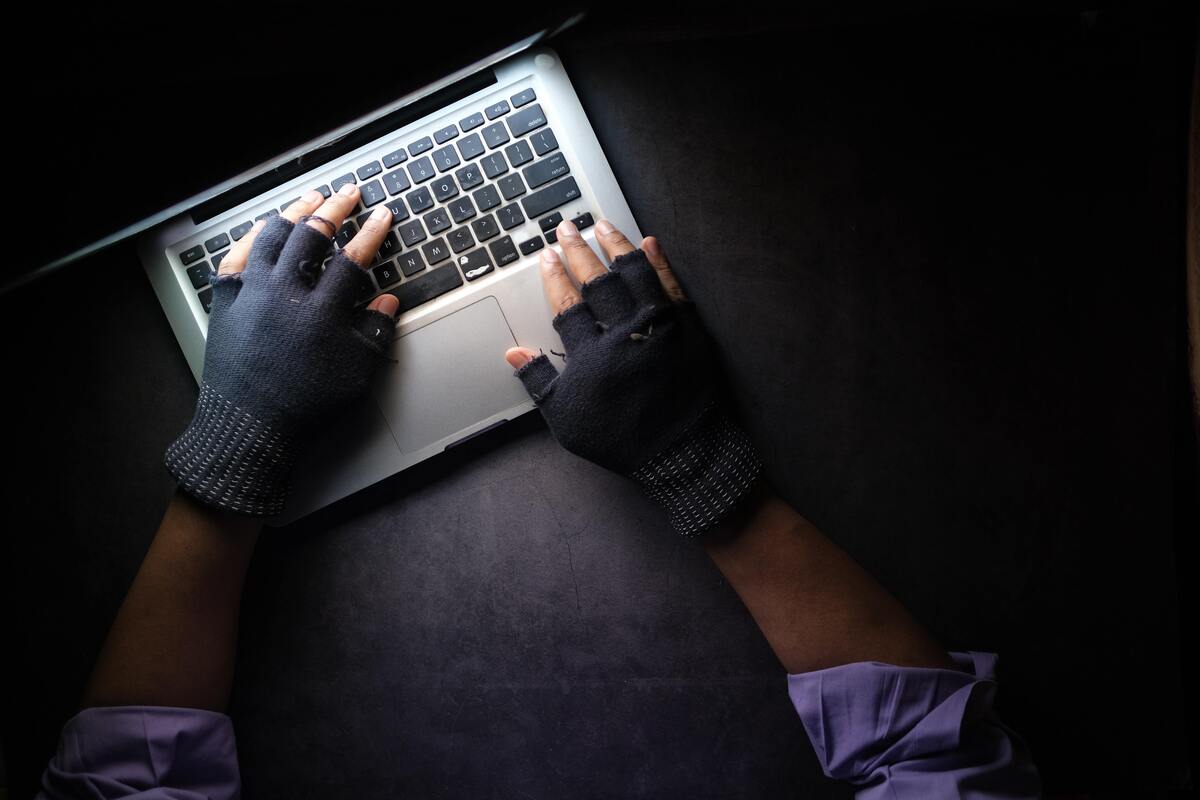 hacker hands stealing data from laptop top down