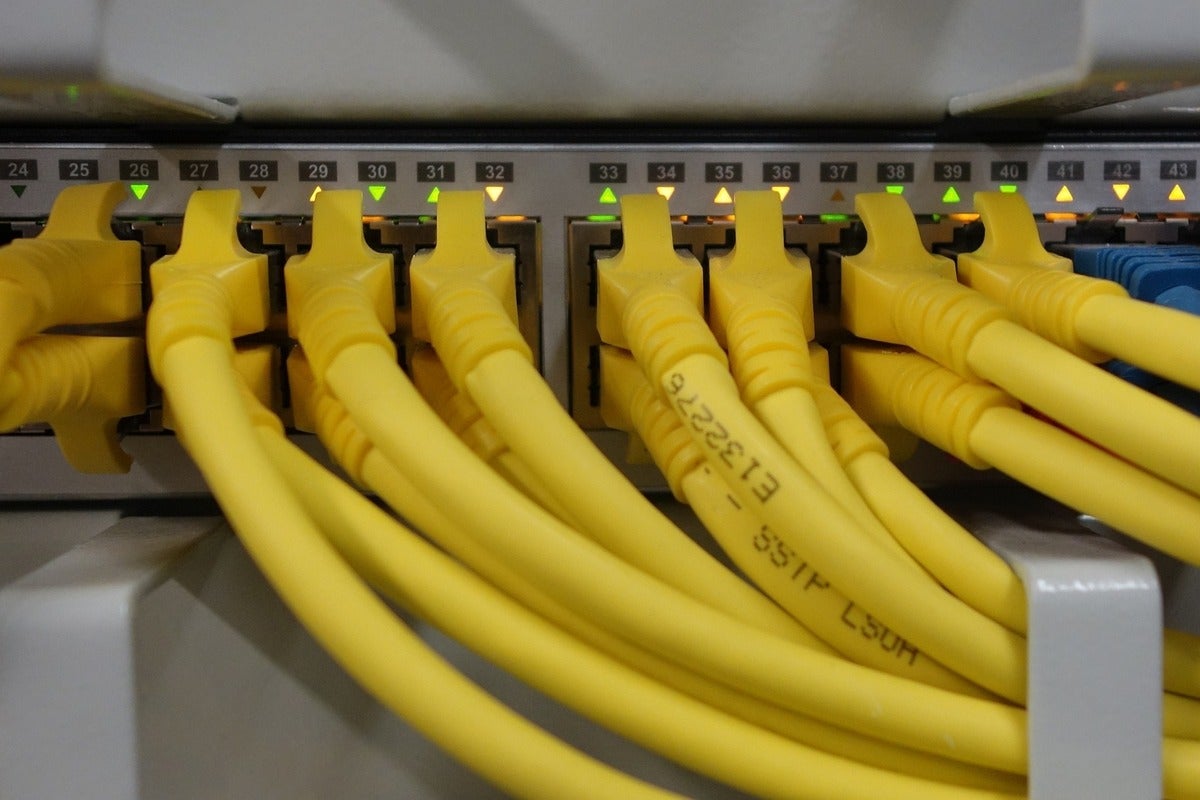 Yellow ethernet cables plugged into a rack